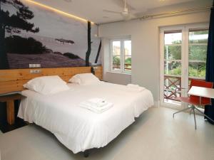 桑坦德桑坦德霍斯蒂亚酒店的卧室配有一张白色大床,墙上挂有绘画作品