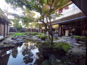 日光Sakahijiri Nikko的一座花园,在一座建筑前设有一个池塘