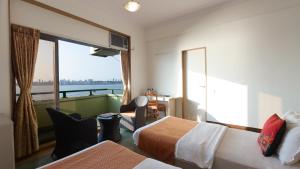 孟买大海绿色酒店 的酒店客房设有两张床和一个阳台。