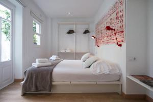 休达德亚经济&时尚酒店的白色卧室,配有带毛巾的床