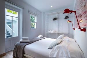 休达德亚经济&时尚酒店的卧室配有带红灯的白色床