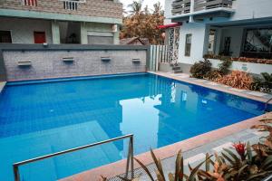 波尔多·格尼拉The Mang-Yan Grand Hotel powered by Cocotel的一座房子前面的蓝色海水游泳池