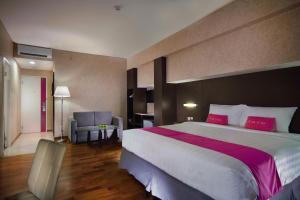 泗水泗水发富格拉古酒店的酒店客房配有一张带红色枕头的大床