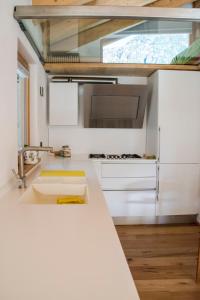 奇萨瓦玛兰科b&bTerre Aromatiche的一间厨房,配有白色的橱柜和大窗户