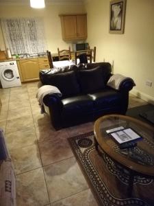 纳文Mullaghbeag Lodge的客厅配有黑色真皮沙发和桌子