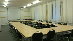 图赫洛维采阿斯特拉酒店的一间会议室,配有桌椅和白板