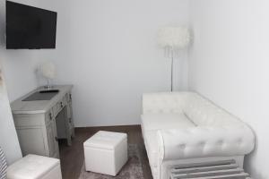 卡拉达沃Boutique Hostal Mistral的客厅配有白色椅子和书桌