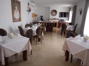 卡拉达沃Boutique Hostal Mistral的一间带白色桌椅的餐厅和一间厨房