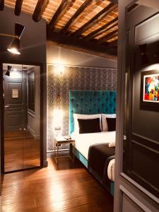 罗马圣B精品STB酒店的一间卧室配有一张蓝色床头板的床