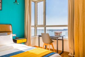 青岛【路客】青岛市黄岛区·青岛银沙滩风景区·路客精品公寓·00146300的一间卧室配有一张床、一张书桌和一个窗户。