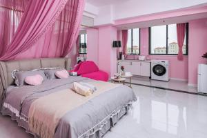 洛阳【路客】洛阳市洛龙区·宝龙城市广场·路客精品公寓·00193320的粉红色的卧室配有一张带粉红色窗帘的大床