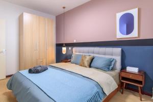 天津【路客】【阿郎】天津站丨海河丨津湾广场的一间卧室配有一张大床和蓝色床头板