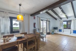 比尼贝卡Villa Bini Andu的一间带木桌和一些窗户的用餐室