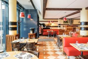 日内瓦日内瓦机场宜必思快捷酒店的一间带桌椅的餐厅和一间酒吧