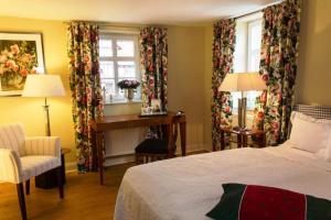 黑塞罗德罗曼蒂克罗森霍夫酒店的卧室配有一张床、一张书桌和窗户。