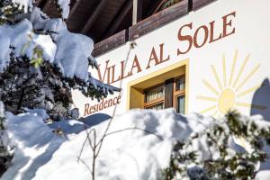 塞尔瓦迪加尔代纳山谷Residence Villa al Sole的一座有矿物销售标志的有雪盖的建筑