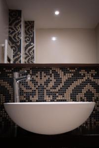 博洛尼亚欧罗巴赞酒店的浴室设有白色水槽和瓷砖墙