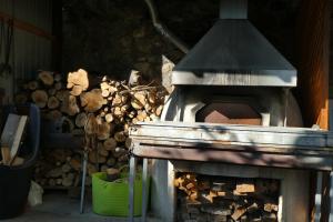 KalokhorioLola's Cottage & Garden的一个带一堆木柴的户外烤箱