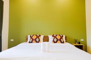 佛丕The Cozy Hotel的一间卧室配有一张白色的床和绿色的墙壁