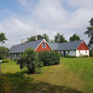 图默利拉4B Österlen Bed & Breakfast的田野中一座有红白色房子的谷仓