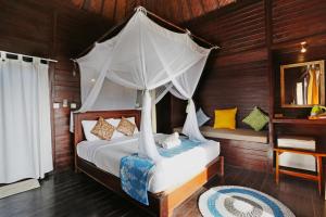蓝梦岛Poh Manis Lembongan的一间卧室配有一张带天蓬的床