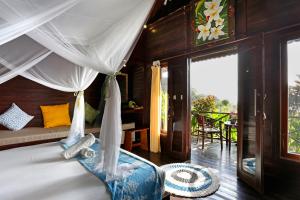 蓝梦岛Poh Manis Lembongan的一间卧室配有一张带天蓬的床和一个庭院。