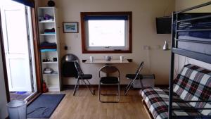 乌伊格Harbor View的客房设有两把椅子、一张桌子和一个窗户。