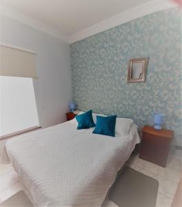 维纳德马维斯塔赫尔摩萨17号酒店的卧室配有白色床和蓝色的墙壁