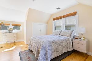 格林波特Greenport Village Vacationer's Delight的一间卧室配有一张床、一个梳妆台和一扇窗户。