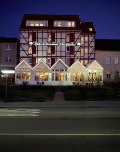 格赖夫斯瓦尔德阿尔特斯派克酒店及餐厅的一座大型建筑,晚上有窗户照明