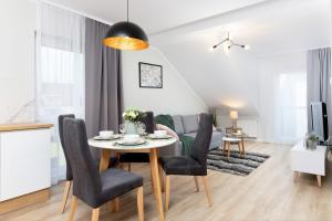 格但斯克Apartments Gdańsk Kochanowskiego by Renters的用餐室以及带桌椅的起居室。