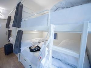 里斯本room00 Lisboa Hostel的宿舍间的两张双层床,配有行李箱