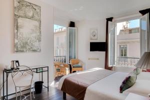 滨海博利厄精选酒店的一间卧室配有两张床和一张桌子及椅子
