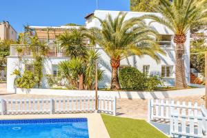 马略卡岛帕尔马Villa Bellver的一座棕榈树白色的房子和一个游泳池