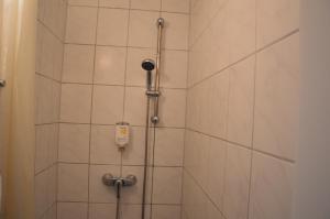 汉堡梅塞德斯中心酒店的浴室铺有白色瓷砖,设有淋浴。