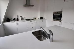 布鲁塞尔Rent a flat - Montgomery的厨房配有水槽和白色台面
