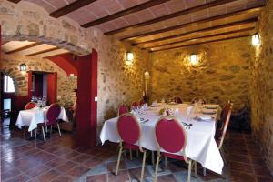 Vall de Ebo琳芬山沟乡村酒店的用餐室配有白色的桌子和红色的椅子