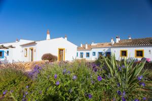 拉戈斯Casas da Capela do Monte, Country Houses的一群白色的房屋,花紫色