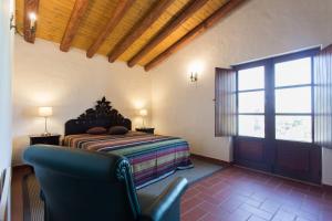拉戈斯Casas da Capela do Monte, Country Houses的卧室配有床、椅子和窗户。