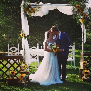 PolzelaLavender Hill, Eko Resort & Wellness的婚礼拱门下的新娘和新郎亲吻