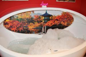Collado MedianoApartamentos DELUXE Con Jacuzzi o Chimenea LOVE FOR TWO的浴缸,带有日本紫禁 ⁇ 、紫禁 ⁇ 、紫禁 ⁇ 的图片