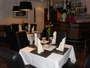 马克兰斯泰特罗森克朗茨餐厅酒店的餐厅配有白色桌椅