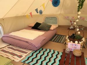 新加坡Glamping Kaki - Medium Bell Tent的帐篷内一间卧室,配有一张床