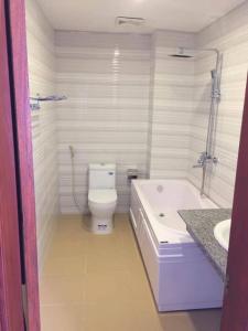 Diễn Châu演州平明酒店的带浴缸、卫生间和盥洗盆的浴室