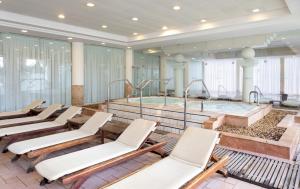 恩波其克Nevo by Isrotel Collection的大型客房设有热水浴缸和椅子。