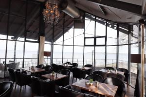 格赖夫斯瓦尔德乌特奇科餐厅酒店的餐厅设有桌椅和大窗户。
