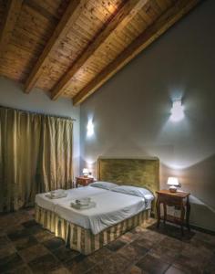多索博诺里卡希迪康帕尼亚农庄酒店的一间卧室配有一张床、两张桌子和两盏灯。