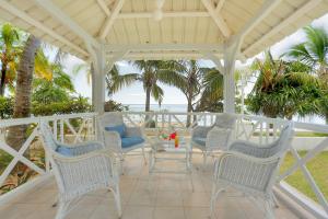 Rodrigues Island库库提尔斯酒店 - 罗德里格斯的一个带椅子和桌子的门廊和大海