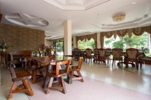 乌隆他尼斯塔尔酒店的用餐室配有木桌和椅子