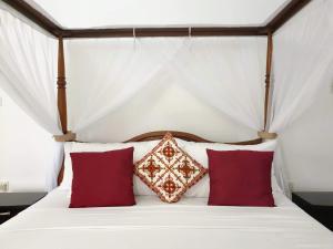 布韦朱Villa Oman的一间卧室配有红色枕头的床